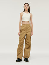 A lady wears light camel cargo pants.
